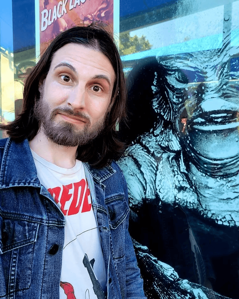 Chris standing beside comic artwork
